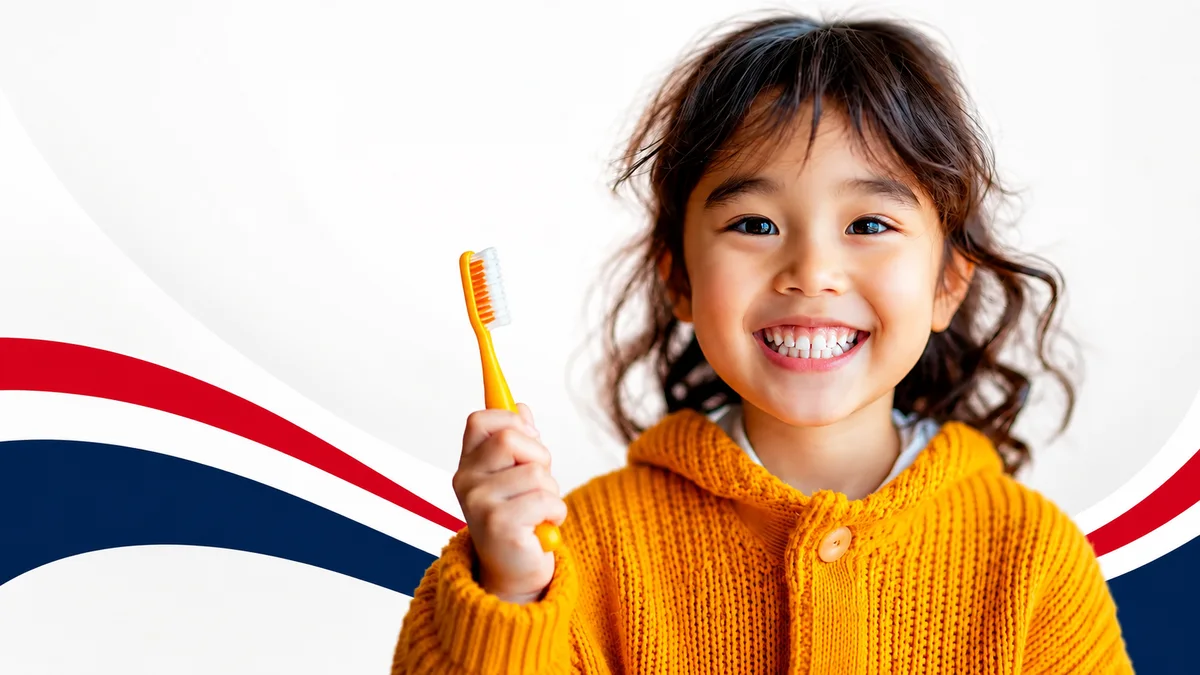 A smiling child holding a toothbrush at Portage Dental Group